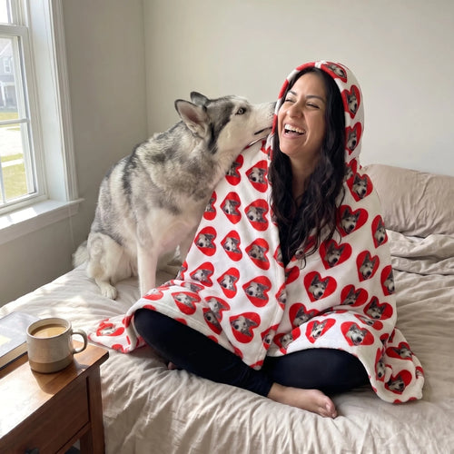 Woman in a custom pet face hooded blanket on her bed as her husky leans in
