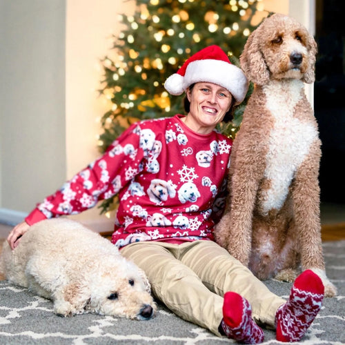 Real customer photo: woman in a red pet face pattern Christmas sweatshirt with her two doodles