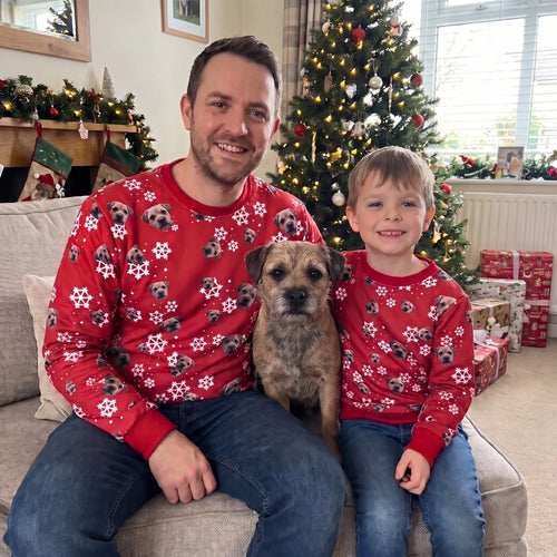 Dad and son in matching pet face pattern Christmas sweatshirts with their border terrier