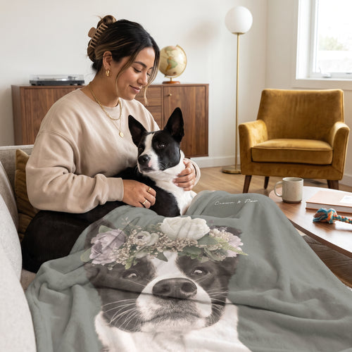 Black-and-white mixed-breed dog with the Full Bloom custom pet blanket: owner + pet on sofa